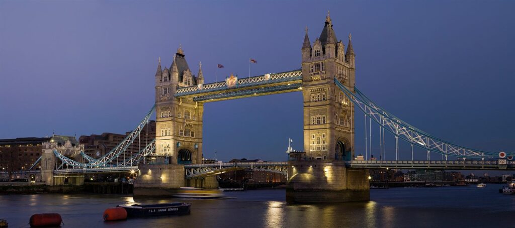 Tower Bridge valaistuna Thamesin yllä hämärän aikaan